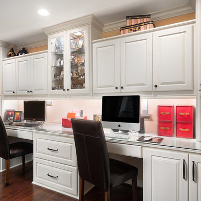 Mid-sized elegant built-in desk medium tone wood floor and brown floor study room photo in Columbus with beige walls