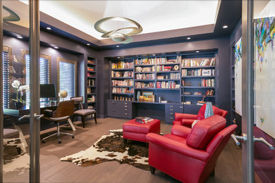 Imagen de despacho contemporáneo grande con paredes azules, suelo de madera oscura, escritorio empotrado y suelo marrón