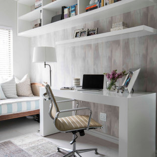Mittelgroßes Klassisches Arbeitszimmer mit Arbeitsplatz, bunten Wänden, freistehendem Schreibtisch, grauem Boden und Tapetenwänden in Sonstige