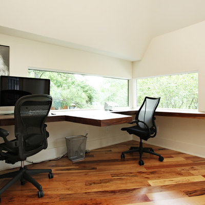 Large trendy built-in desk medium tone wood floor study room photo in Austin with white walls and no fireplace