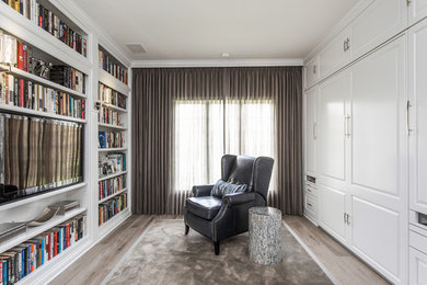 ニューヨークにある高級な中くらいなトランジショナルスタイルのおしゃれなホームオフィス・書斎 (ライブラリー、グレーの壁、淡色無垢フローリング、造り付け机) の写真