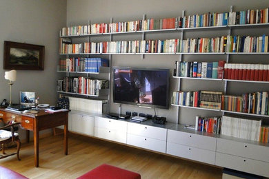 Imagen de despacho contemporáneo de tamaño medio con biblioteca, suelo de madera en tonos medios, paredes blancas y suelo marrón