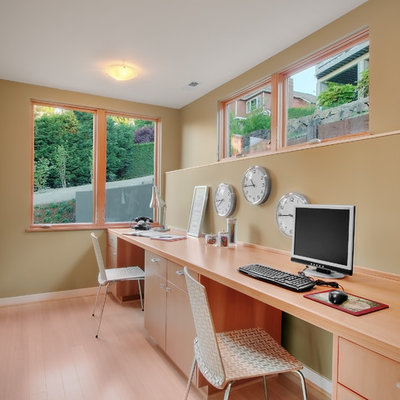 Example of a trendy built-in desk medium tone wood floor home office design in Seattle