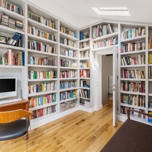 Photo of a contemporary home office in London with a reading nook, medium hardwood flooring, a freestanding desk and brown floors.