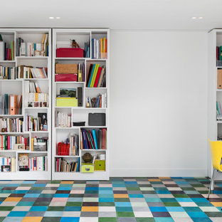 Modern inredning av ett mellanstort hemmabibliotek, med vita väggar, klinkergolv i keramik, ett fristående skrivbord och flerfärgat golv