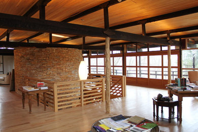 Ejemplo de despacho de estilo zen grande sin chimenea con paredes marrones, suelo de madera clara y escritorio independiente