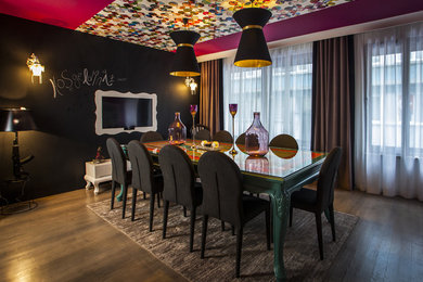 Example of an eclectic dark wood floor dining room design in Other with black walls