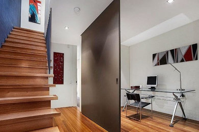 This is an example of a medium sized modern study in Melbourne with a freestanding desk.