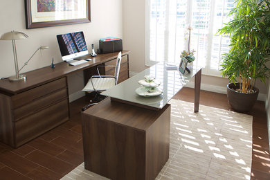 Diseño de despacho actual pequeño con paredes beige, suelo de madera en tonos medios y escritorio independiente