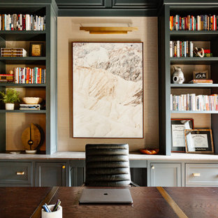 Inspiration för ett mellanstort vintage hemmabibliotek, med gröna väggar, mellanmörkt trägolv, en standard öppen spis, en spiselkrans i sten, ett fristående skrivbord och brunt golv