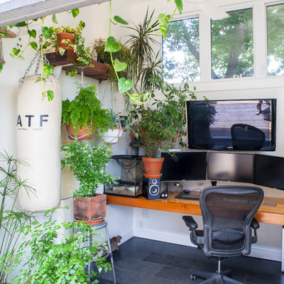 Example of an eclectic built-in desk gray floor home office design in Toronto with white walls