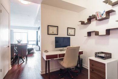 Kleines Modernes Arbeitszimmer ohne Kamin mit weißer Wandfarbe, dunklem Holzboden und freistehendem Schreibtisch in Toronto
