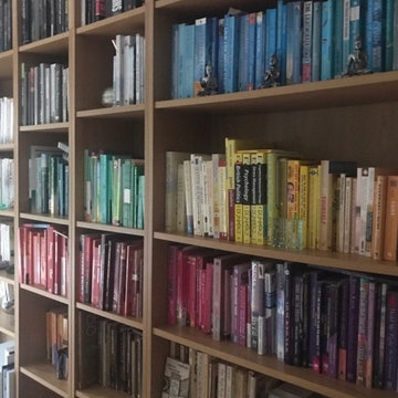 Large wall mounted shelf, colour coded books, prior to painting.