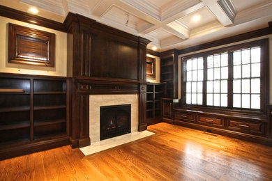 Imagen de despacho clásico con paredes beige, suelo de madera clara y todas las chimeneas