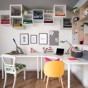 Mittelgroßes Eklektisches Arbeitszimmer ohne Kamin mit Studio, weißer Wandfarbe, Laminat, freistehendem Schreibtisch und braunem Boden in Edinburgh