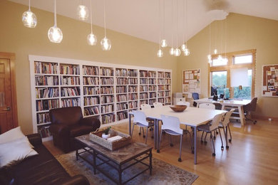 カンザスシティにある広いコンテンポラリースタイルのおしゃれなホームオフィス・書斎 (ライブラリー、ベージュの壁、無垢フローリング、暖炉なし、自立型机、茶色い床) の写真