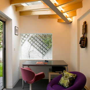 This is an example of a small contemporary study in London with white walls, a freestanding desk, black floors and no fireplace.