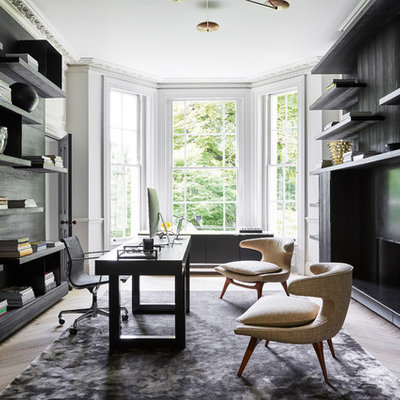 Large trendy freestanding desk light wood floor and beige floor study room photo in London