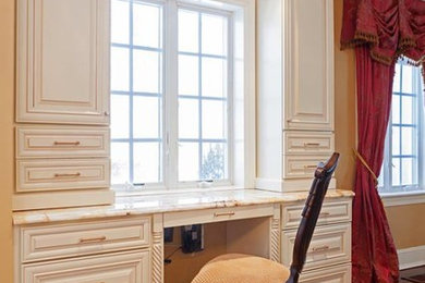 Ejemplo de despacho clásico de tamaño medio sin chimenea con paredes beige, suelo de madera oscura y escritorio empotrado
