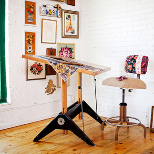 Stilmix Arbeitszimmer mit Studio, weißer Wandfarbe, braunem Holzboden und freistehendem Schreibtisch in Denver