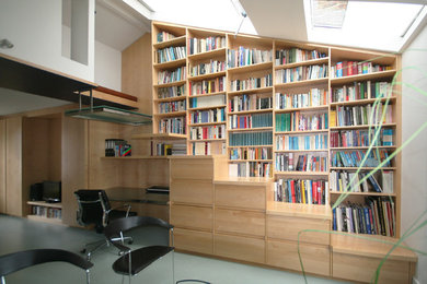 Bild på ett funkis hemmabibliotek, med ett inbyggt skrivbord