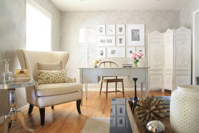 Imagen de despacho clásico con biblioteca, paredes grises, suelo de madera en tonos medios y escritorio independiente