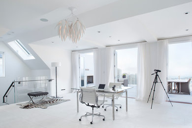 Ejemplo de despacho moderno con paredes blancas y escritorio independiente