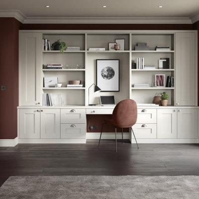 Example of a mid-sized classic built-in desk medium tone wood floor and brown floor study room design in Manchester with red walls