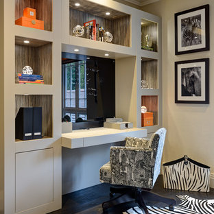 Mittelgroßes Klassisches Arbeitszimmer mit beiger Wandfarbe, dunklem Holzboden, Einbau-Schreibtisch und schwarzem Boden in Surrey