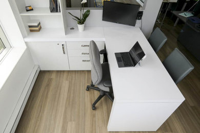 На фото: рабочее место среднего размера в современном стиле с серыми стенами, паркетным полом среднего тона и встроенным рабочим столом