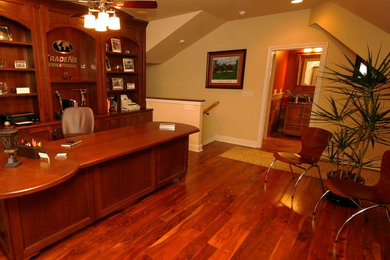 Study room - large traditional built-in desk medium tone wood floor study room idea in Other with beige walls