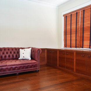 Transitional built-in desk medium tone wood floor study room photo in New York with beige walls