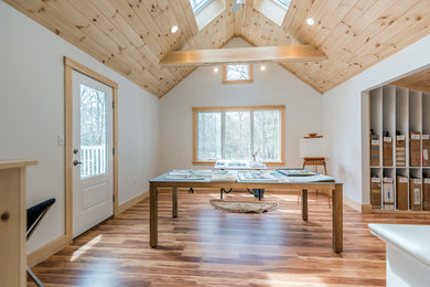 Example of a mid-sized trendy freestanding desk medium tone wood floor and brown floor home studio design in Boston with white walls