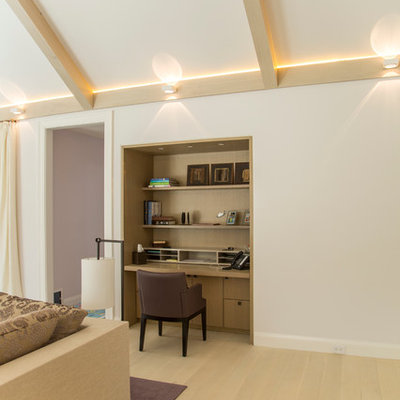 Example of a small trendy built-in desk light wood floor study room design in New York with white walls
