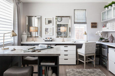 На фото: домашняя мастерская среднего размера в стиле неоклассика (современная классика) с серыми стенами, полом из ламината и встроенным рабочим столом с