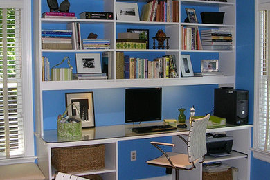 Example of a mid-sized trendy built-in desk medium tone wood floor home office design in Richmond with blue walls and no fireplace