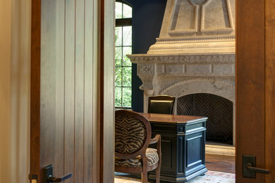 サンフランシスコにある地中海スタイルのおしゃれなホームオフィス・書斎 (黒い壁、標準型暖炉、コンクリートの暖炉まわり) の写真