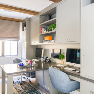 Großes Mediterranes Arbeitszimmer mit weißer Wandfarbe, braunem Holzboden, Einbau-Schreibtisch und braunem Boden in Orange County