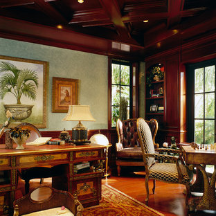 Großes Mediterranes Arbeitszimmer mit braunem Holzboden, freistehendem Schreibtisch, Arbeitsplatz, grüner Wandfarbe und braunem Boden in Miami