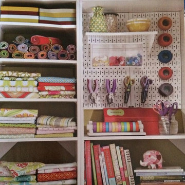 Metal pegboard w/ shelving and bins and rolling fabric squares for organizing st