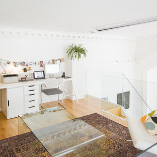 Immagine di un piccolo atelier scandinavo con pareti bianche, pavimento in legno massello medio, nessun camino e scrivania incassata