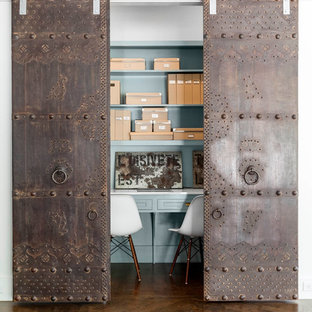 This is an example of a contemporary home office in Dallas with blue walls, dark hardwood flooring, no fireplace and a built-in desk.