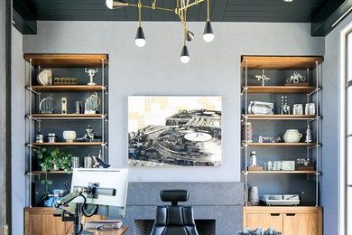 Diseño de despacho negro retro sin chimenea con paredes grises y escritorio independiente