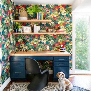 Cette image montre un bureau marin de taille moyenne avec un mur multicolore, un sol en bois brun, un bureau intégré et un sol marron.