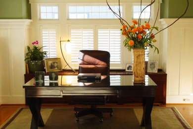 Ejemplo de despacho de estilo americano de tamaño medio con paredes verdes, suelo de madera en tonos medios y escritorio independiente