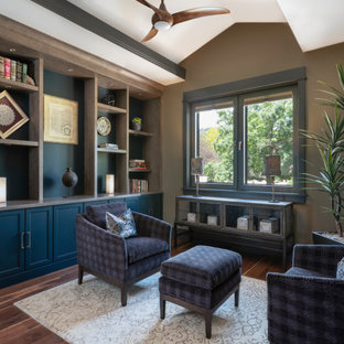 Immagine di uno studio stile americano di medie dimensioni con libreria, pareti multicolore, pavimento in legno massello medio e pavimento marrone