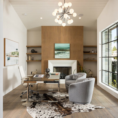 Study room - cottage freestanding desk medium tone wood floor and brown floor study room idea in Orange County with white walls, a standard fireplace and a wood fireplace surround