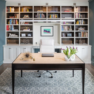 Example of a mid-sized transitional freestanding desk dark wood floor and brown floor home office design in Milwaukee with blue walls and no fireplace