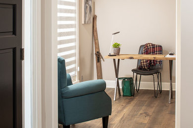 Ejemplo de despacho de estilo de casa de campo de tamaño medio con paredes grises, suelo de madera en tonos medios, escritorio independiente y suelo marrón