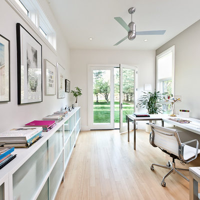 Example of a large trendy freestanding desk light wood floor and beige floor home office design in Los Angeles with gray walls